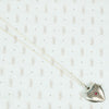 silver hearl locket with an interesting petit point design