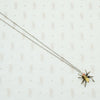 sterling silver with gold details this spider pendant is set with an opal body and garnet eyes