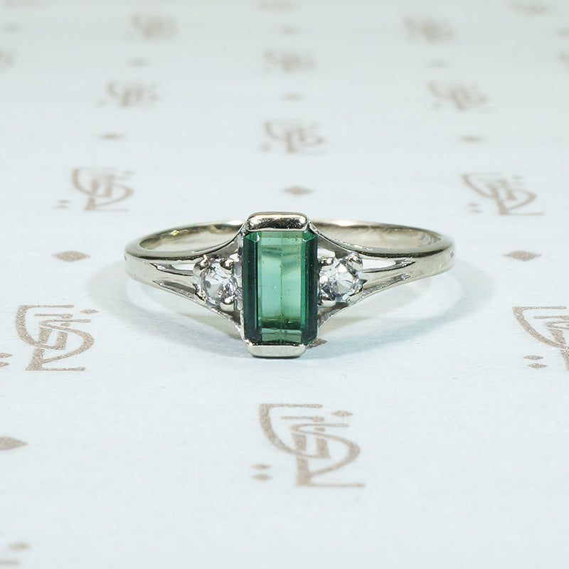 emerald cut gren tourmaline flanked by round white sapphires in 10k white gold ring