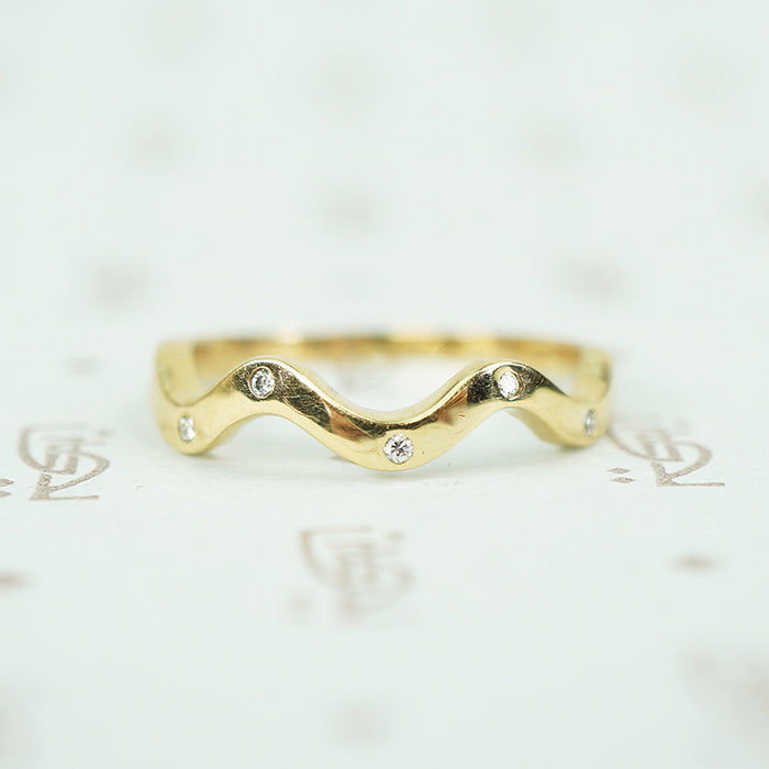 14k recycled yellow gold wave band with 5 flush set tiny round diamonds
