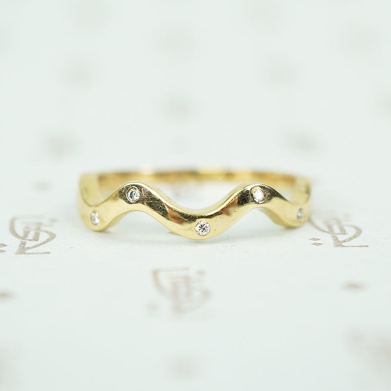 14k recycled yellow gold wave band with 5 flush set tiny round diamonds
