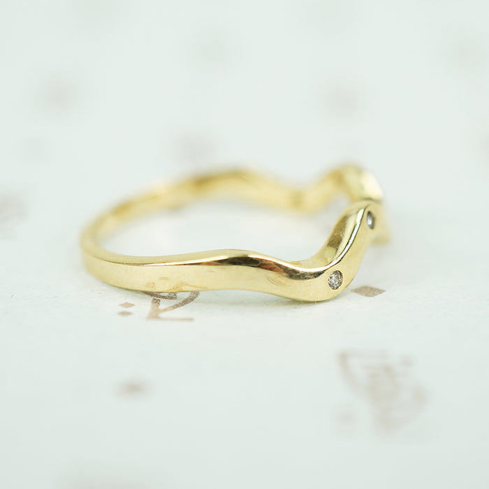 side view showing flat back and wave front of 14k yellow gold wave band